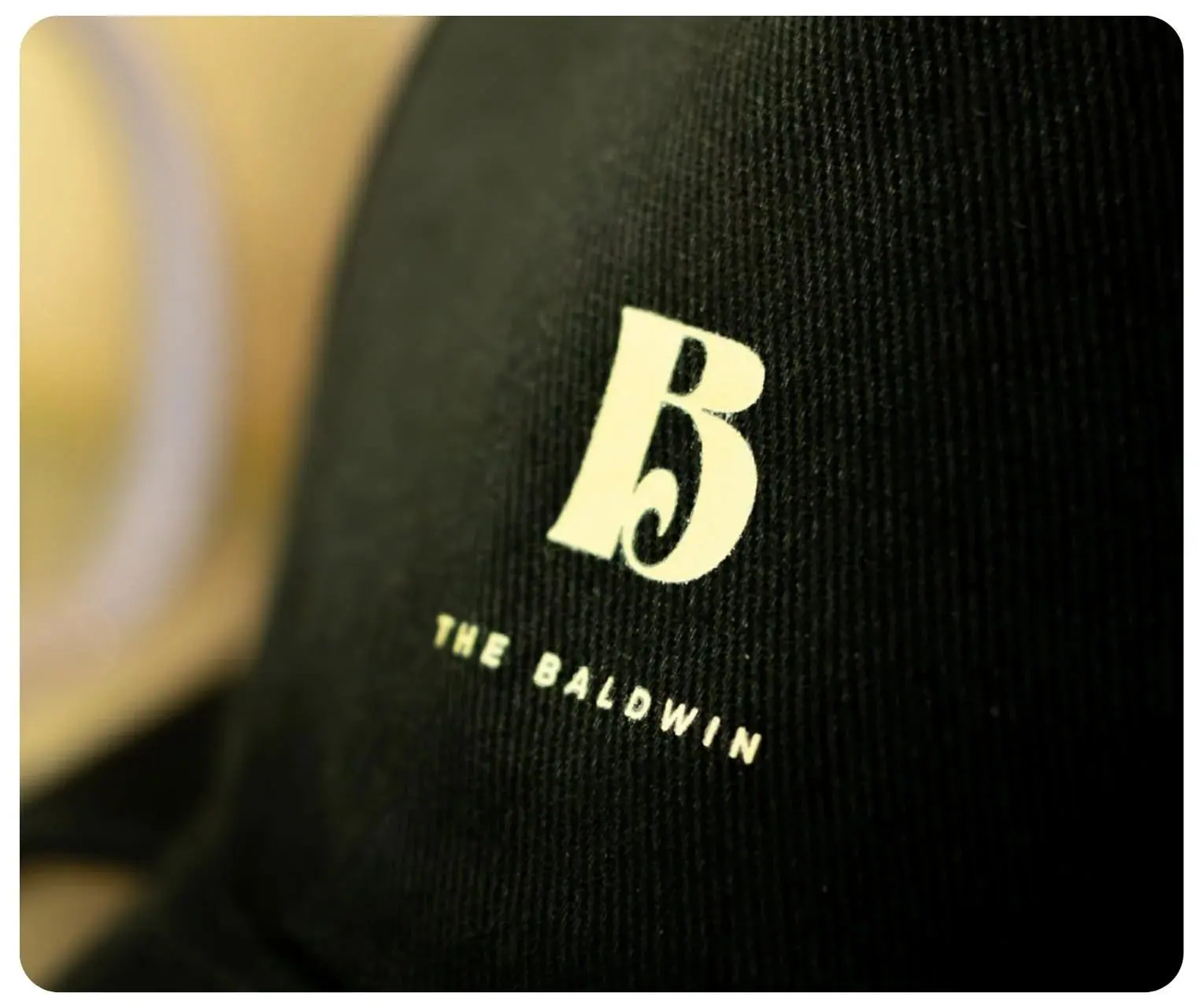 The Baldwin B monogram embroidered in cream on a black cap